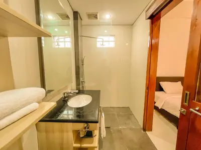 a bathroom with a sink and a mirror and a bed at Jasmine Villa in Nusa Dua