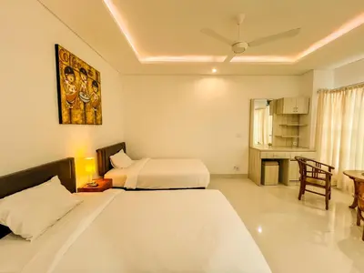 a hotel room with two beds and a table at Jasmine Villa in Nusa Dua