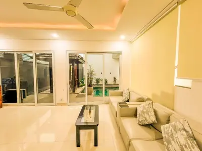 a living room with a couch and a table at Jasmine Villa in Nusa Dua