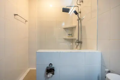 a white bathroom with a shower and a toilet at Mich Bali Villa Two-Bedroom Private Pool Kuta in Seminyak