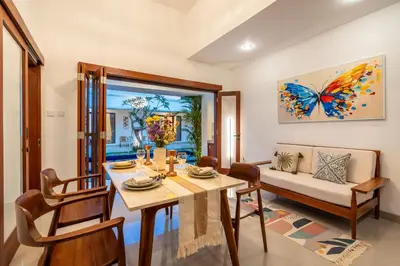 a dining room with a table and a butterfly painting on the wall at Mich Bali Villa Two-Bedroom Private Pool Kuta in Seminyak