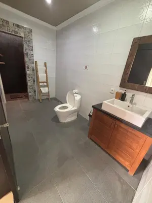 a bathroom with a toilet and a sink at Sirkus Guesthouse in Canggu