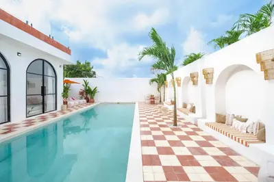 a pool in a house with a checkered floor at Ocean View 4BR Design Villa with Lap Pool & Rooftop Jacuzzi in Jimbaran