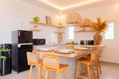 a kitchen with a large wooden table and chairs at Anatari 3 BR Private Pool Villa in Seminyak