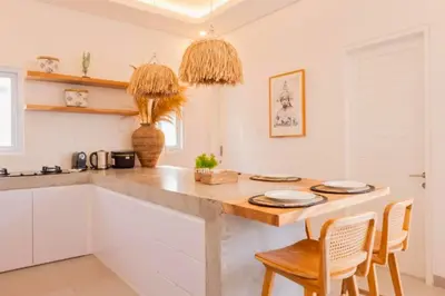 a kitchen with a large wooden table and chairs at Anatari 3 BR Private Pool Villa in Seminyak