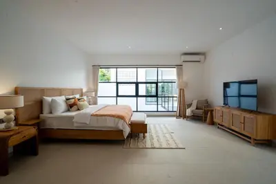 a bedroom with a large bed and a television at Leva Villa - Luxury 3BR Jimbaran in Jimbaran
