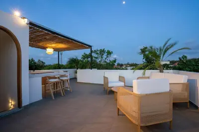 a patio with chairs and a bar on a roof at Leva Villa - Luxury 3BR Jimbaran in Jimbaran