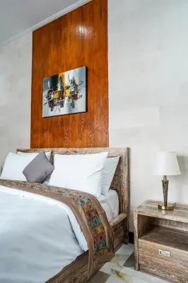 a bedroom with a bed with a wooden headboard at Villa Maharani Sanur in Sanur