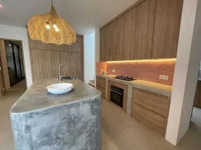 a kitchen with a concrete counter with a sink on it at Tropical Chic Villa w Rooftop & Pool in Seminyak in Seminyak