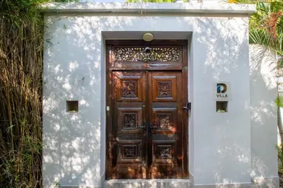 a wooden door in a white wall with at D Villa Seminyak in Seminyak