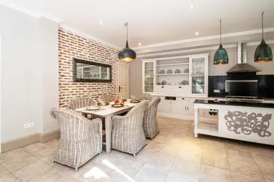 a kitchen with a table and wicker chairs at D Villa Seminyak in Seminyak