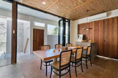 a dining room with a wooden table and chairs at Shankara 2 BR Private Pool Villa in Seminyak