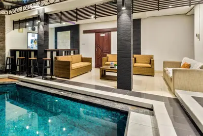 a pool in a room with furniture and a living room at Balinese Home with Pool near Padma Beach, Legian in Legian