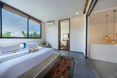 a bedroom with a large bed and a large window at Quilon 2 BR Private Pool Villa in Seminyak