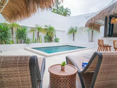 a patio with a table and chairs and a swimming pool at Harbie Villa 1 in Seminyak