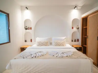 a white bedroom with a large bed with white sheets at Harbie Villa 1 in Seminyak