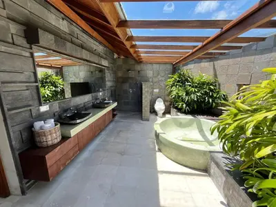 a bathroom with two sinks and a bath tub at Bumahan Villa in Seminyak