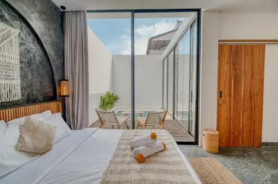 a bedroom with a bed with a teddy bear on it at FYM LOVE VILLA Residence BALI in Kerobokan