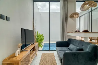 a living room with a blue couch and a tv at FYM LOVE VILLA Residence BALI in Kerobokan
