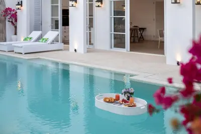 a swimming pool with a tray of food in the water at Colonial House 4BR Villa With Ocean View in Berawa in Canggu