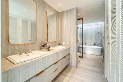a bathroom with two sinks and two mirrors at Colonial House 4BR Villa With Ocean View in Berawa in Canggu