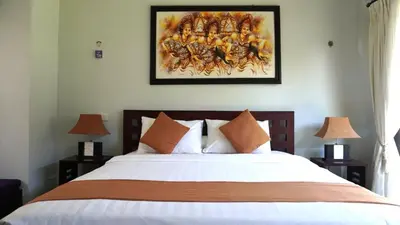 a bedroom with a large bed with two lamps at Tahoma Villas Seminyak by ABM in Seminyak