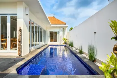 a swimming pool in front of a house at Ardelle 2 BR Private Pool Villa in Canggu