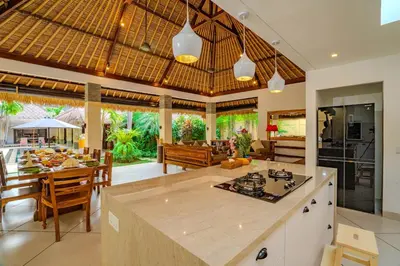 an open kitchen and living room with a table and chairs at Villa Evelyne, Luxury Villa, Fully Staffed, Central Seminyak in Seminyak