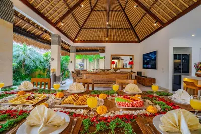 a dining room with a table filled with food at Villa Evelyne, Luxury Villa, Fully Staffed, Central Seminyak in Seminyak