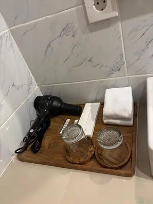 a hair dryer on a cutting board on a bathroom counter at Casa Benoa Homestay in Nusa Dua