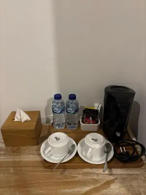 a wooden table with plates and water bottles on it at Casa Benoa Homestay in Nusa Dua