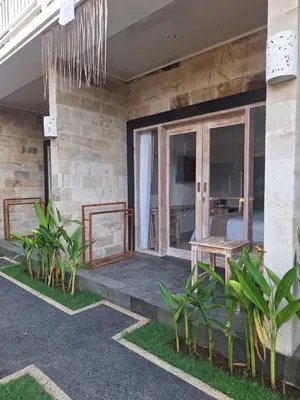 a porch of a house with a bed at Casa Benoa Homestay in Nusa Dua