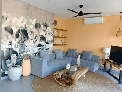 a living room with a blue couch and a table at Tropikal villa 2 bedrooms in seminyak Bali in Seminyak