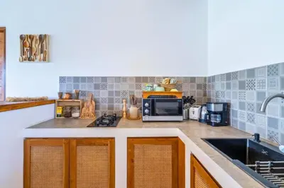 a kitchen with a sink and a microwave at Avery 1 BR Private Pool Villa in Seminyak