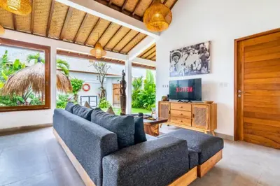 a living room with couches and a television at Avery 1 BR Private Pool Villa in Seminyak