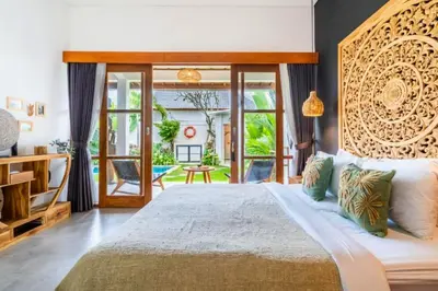 a bedroom with a large bed and a balcony at Avery 1 BR Private Pool Villa in Seminyak
