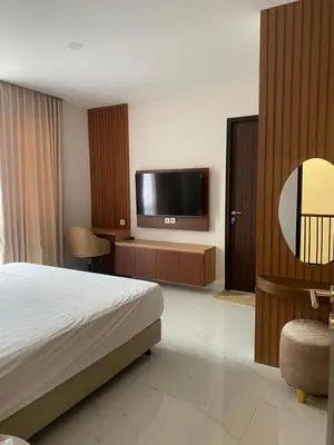 a hotel room with a bed and a flat screen tv at Villa Bun Blessi in Pesanggaran