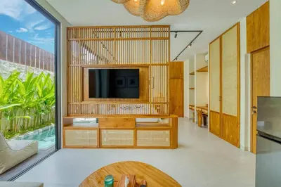 a living room with a tv on a wall at Tropical 3BR Villa 2 Private Pools in Jimbaran in Jimbaran