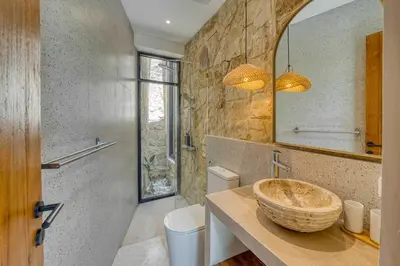 a bathroom with a sink and a toilet and a mirror at Tropical 3BR Villa 2 Private Pools in Jimbaran in Jimbaran