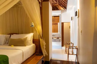 a bedroom with a bed and a doorway to a bathroom at Villa Elegant by Exotiq in Seminyak