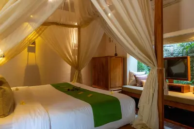 a bedroom with a canopy bed and a tv at Villa Elegant by Exotiq in Seminyak