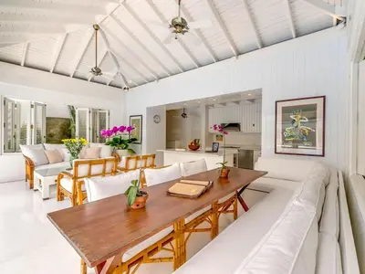 a dining room and living room with a wooden table at Villa Lulito in Seminyak