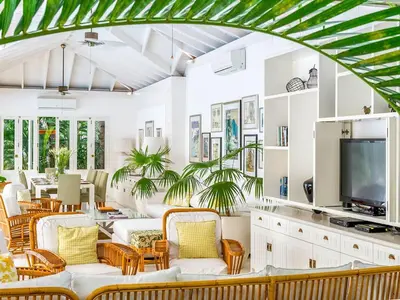 a living room with white furniture and a tv at Villa Lulito in Seminyak