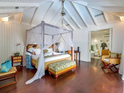 a bedroom with a canopy bed with two people in it at Villa Lulito in Seminyak