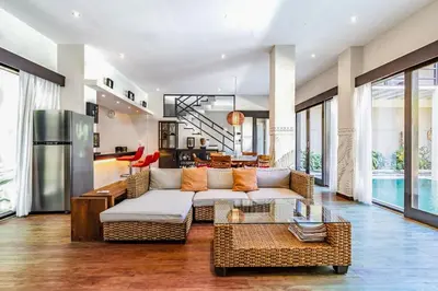 a living room with a couch and a table at Panatai Villa in Sanur