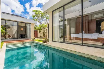 a house with a swimming pool next to a bedroom at Jimbaran Villa in Jimbaran