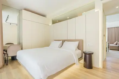a bedroom with a large white bed and a desk at Layur Villa in Canggu