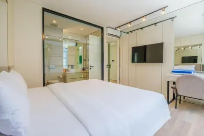 a bedroom with a large white bed and a desk at Layur Villa in Canggu
