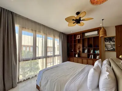 a bedroom with a bed and a large window at Luxury Berawa Private 3BR Villa With Butler in Canggu