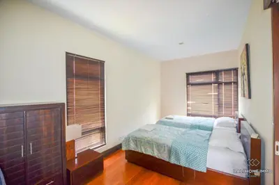 a bedroom with a bed and two windows at Villa Ayu in Kerobokan